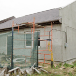 Вид дома с незавершённой реконструкцией и строительными лесами, зафиксированный экспертами.