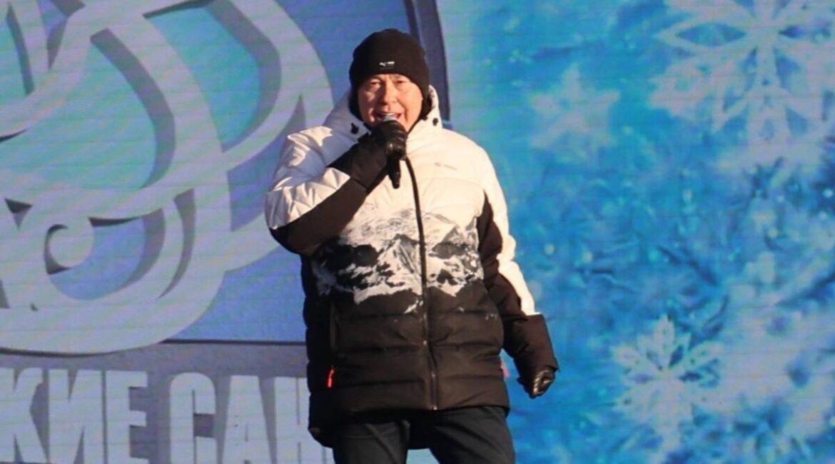 Александр Солодуха выступает на сцене в Бресте во время фестиваля «Берестейские сани» в зимней куртке.