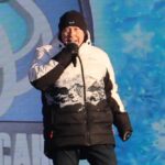 Александр Солодуха выступает на сцене в Бресте во время фестиваля «Берестейские сани» в зимней куртке.